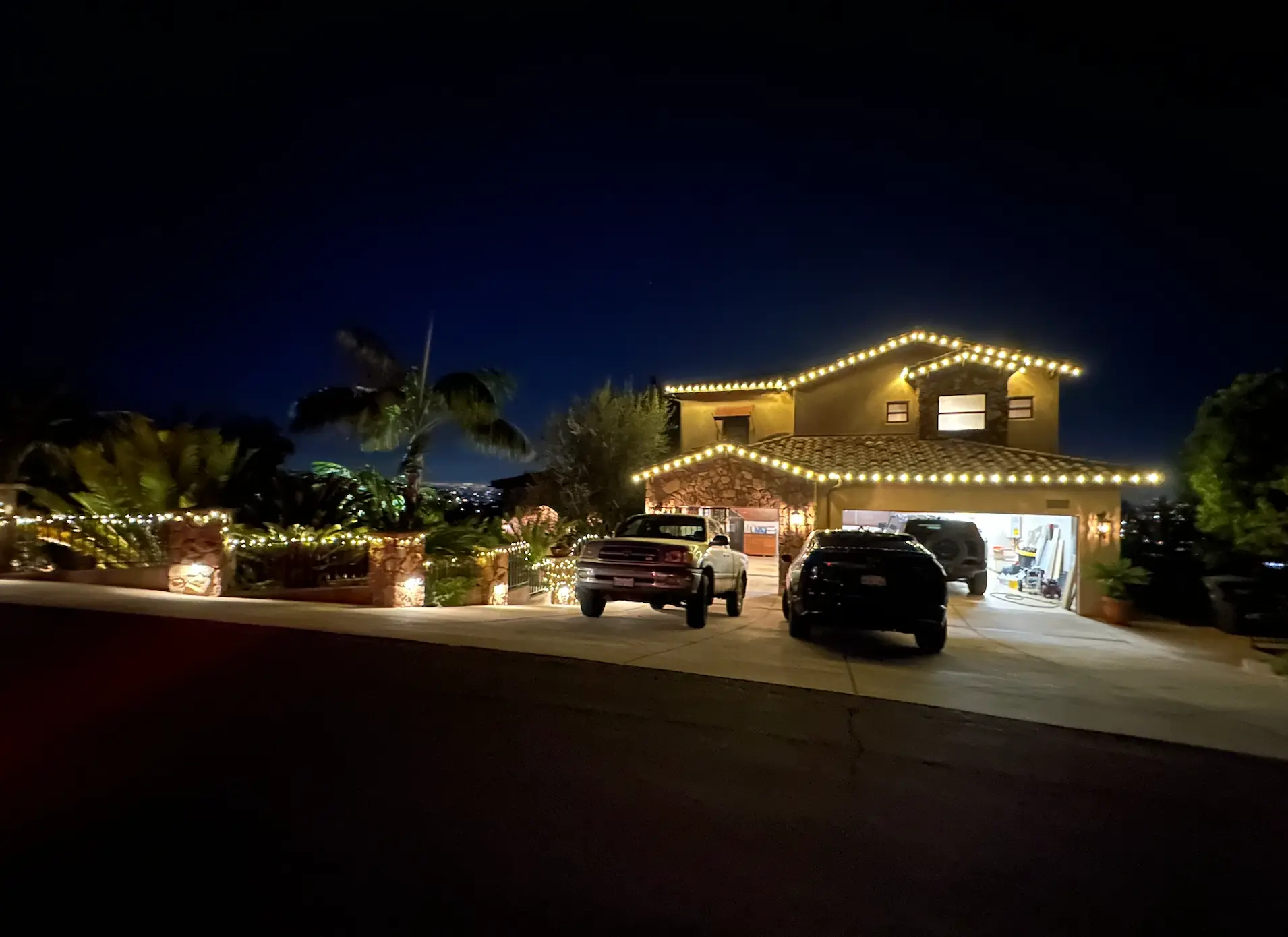 Night — the same home illuminated by its permanent lighting system