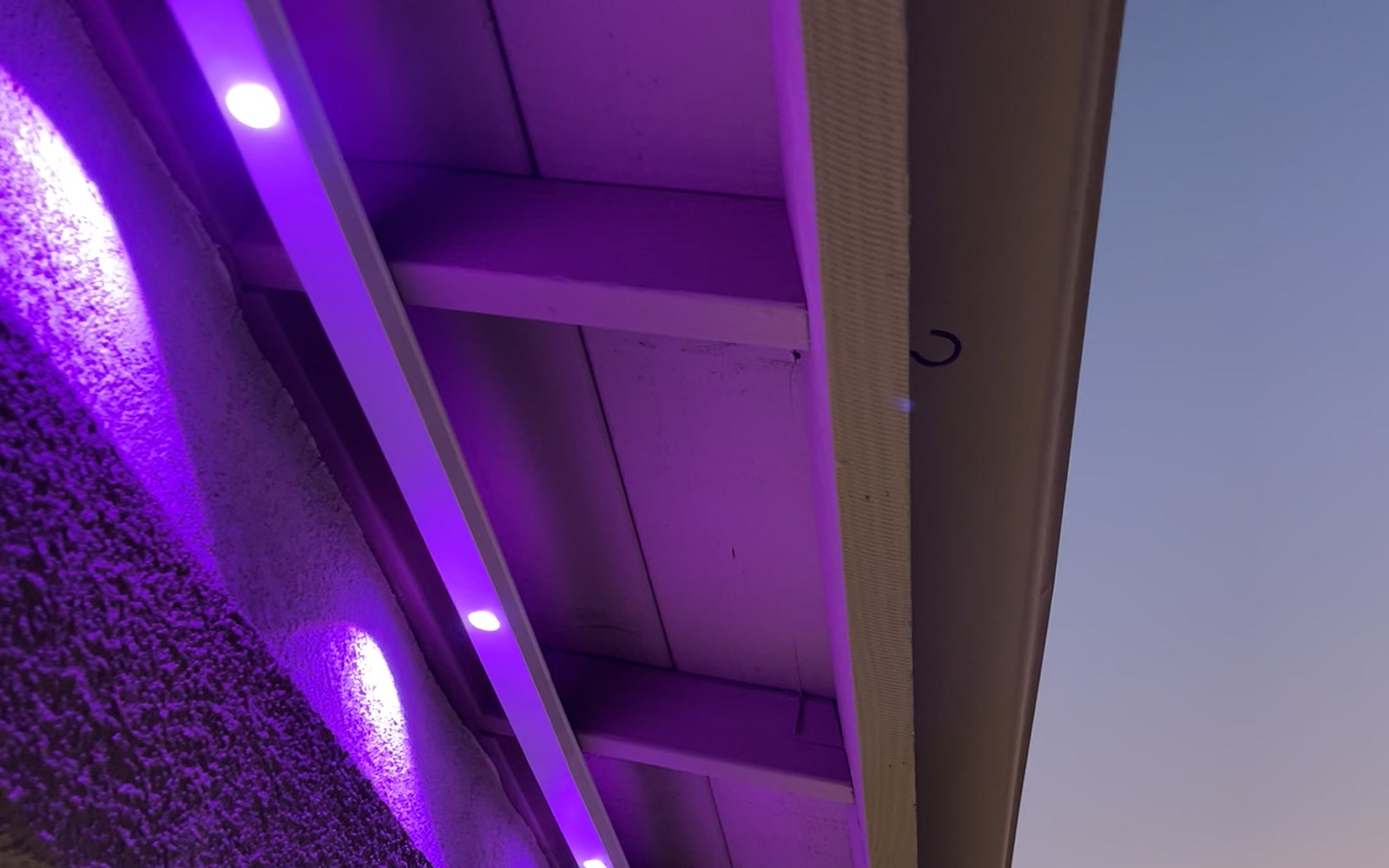 Purple permanent lighting installed beneath a San Diego home's eave