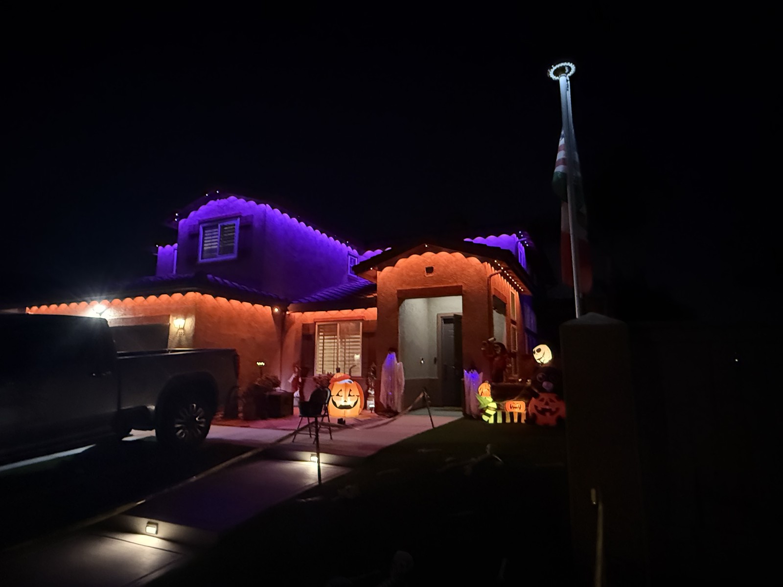 Night — the same home illuminated by its permanent lighting system